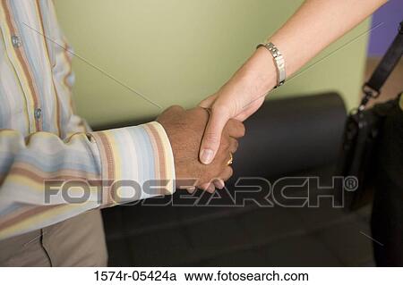 Businessman and a businesswoman shaking hands View Large Photo Image Stock Image - Businessman and a businesswoman shaking hands. Fotosearch