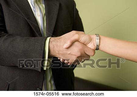 Businessman and a businesswoman shaking hands View Large Photo Image Stock Photograph - Businessman and a businesswoman shaking hands. Fotosearch