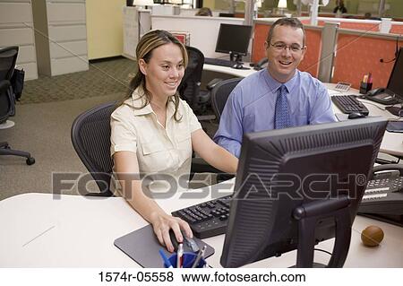 Businessman and a businesswoman using a computer View Large Photo Image Stock Photo - Businessman and a businesswoman using a computer. Fotosearch