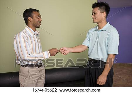 Businessman handing a business card to another businessman View Large Photo Image Stock Image - Businessman handing a business card to another businessman. Fotosearch