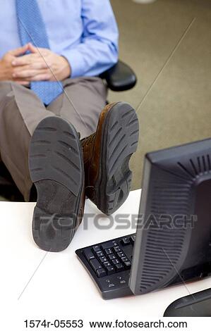Businessman with his feet up on a desk View Large Photo Image Stock Image - Businessman with his feet up on a desk. Fotosearch
