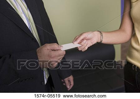 Stock Photo - Businesswoman giving a business card to a businessman. Fotosearch