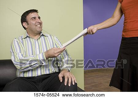 Businesswoman giving a document to a businessman View Large Photo Image Picture - Businesswoman giving a document to a businessman. Fotosearch