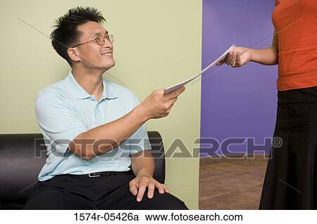 Businesswoman giving a document to a businessman View Large Photo Image Stock Image - Businesswoman giving a document to a businessman. Fotosearch