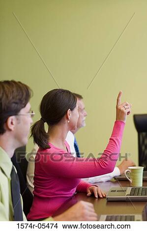 Businesswoman raising her hand in a conference View Large Photo Image Picture - Businesswoman raising her hand in a conference. Fotosearch
