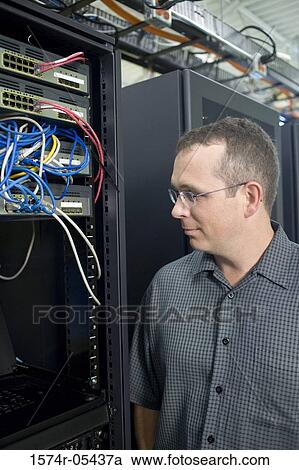 Stock Image - Close-up of technician looking at a network server. Fotosearch