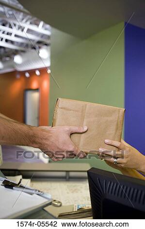 Delivery man delivering a parcel View Large Photo Image Stock Image - Delivery man delivering a parcel. Fotosearch