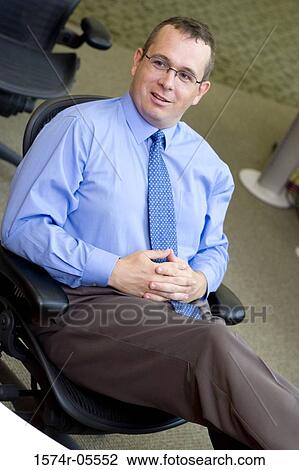 High angle view of a businessman sitting on a chair View Large Photo Image Stock Image - High angle view of a businessman sitting on a chair. Fotosearch