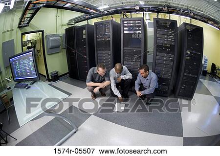High angle view of three technicians crouching in front of a network server View Large Photo Image Stock Photo - High angle view of three technicians crouching in front of a network server. Fotosearch