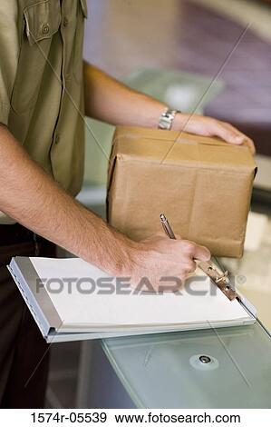 Mid section view of a delivery man writing on a clipboard View Large Photo Image Stock Photo - Mid section view of a delivery man writing on a clipboard. Fotosearch