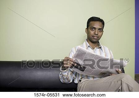 Portrait of a businessman sitting on a couch reading a newspaper View Large Photo Image Stock Image - Portrait of a businessman sitting on a couch reading a newspaper. Fotosearch