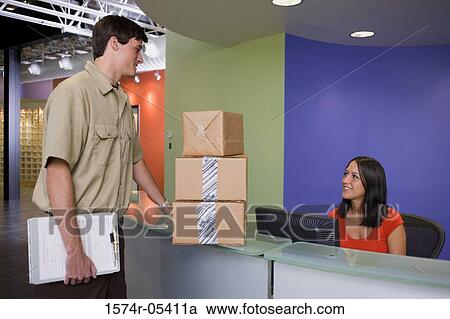 Receptionist receiving a package from a delivery man View Large Photo Image Stock Image - Receptionist receiving a package from a delivery man. Fotosearch