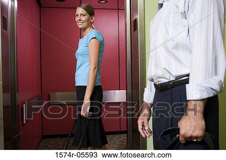 Stock Image - Side profile of a businesswoman waiting for an elevator. Fotosearch