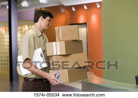 Side profile of a delivery man holding a stack of boxes View Large Photo Image Picture - Side profile of a delivery man holding a stack of boxes. Fotosearch