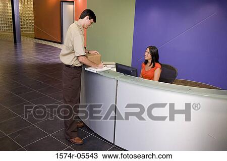 Side profile of a delivery man writing on a clipboard in front of a receptionist View Large Photo Image Stock Image - Side profile of a delivery man writing on a clipboard in front of a receptionist. Fotosearch