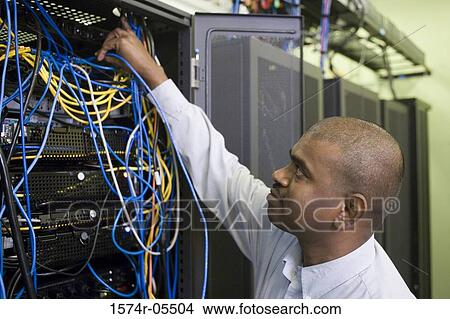 Side profile of a technician repairing network server cables View Large Photo Image Picture - Side profile of a technician repairing network server cables. Fotosearch