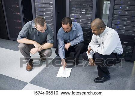 Three technicians crouching in front of a network server View Large Photo Image Stock Image - Three technicians crouching in front of a network server. Fotosearch