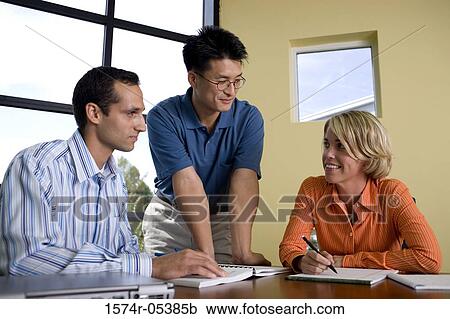 Two businessmen and a businesswoman reading documents View Large Photo Image Stock Image - Two businessmen and a businesswoman reading documents. Fotosearch