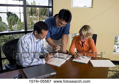 Two businessmen and a businesswoman reading documents View Large Photo Image Stock Photo - Two businessmen and a businesswoman reading documents. Fotosearch