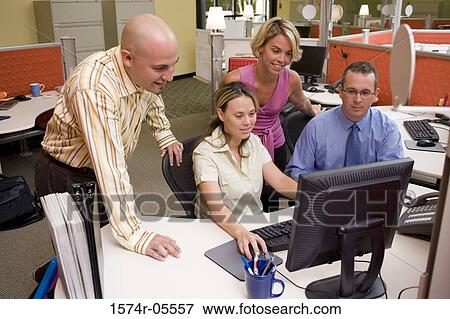 Two businessmen and two businesswomen using a computer View Large Photo Image Stock Photo - Two businessmen and two businesswomen using a computer. Fotosearch