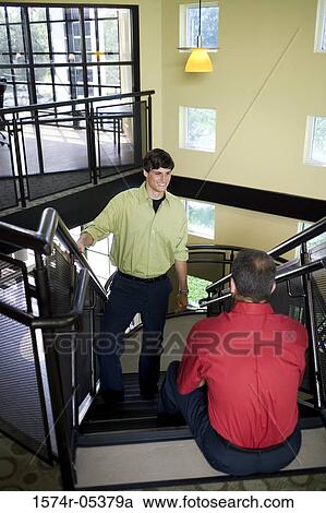 Two businessmen talking on stairs View Large Photo Image Stock Image - Two businessmen talking on stairs. Fotosearch