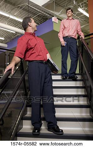 Two businessmen talking on stairs View Large Photo Image Stock Image - Two businessmen talking on stairs. Fotosearch