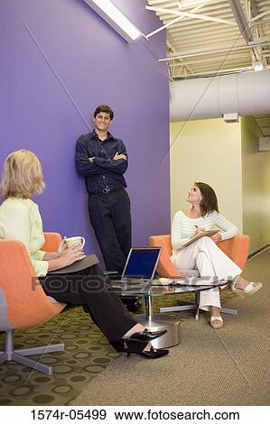 Two businesswomen and a businessman talking to each other View Large Photo Image Stock Photo - Two businesswomen and a businessman talking to each other. Fotosearch