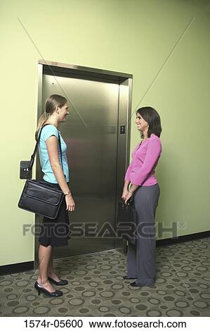 Two businesswomen waiting for an elevator View Large Photo Image Stock Image - Two businesswomen waiting for an elevator. Fotosearch