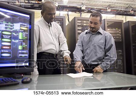 Two technicians standing in front of a network server View Large Photo Image Stock Image - Two technicians standing in front of a network server. Fotosearch