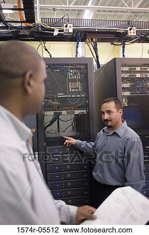 Two technicians talking in front of a network server View Large Photo Image Stock Image - Two technicians talking in front of a network server. Fotosearch
