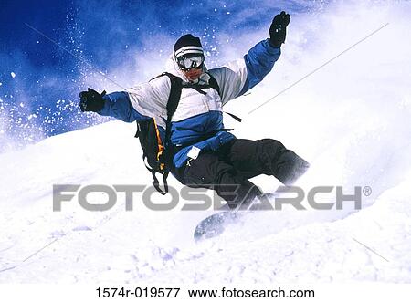Stock Photo - Low angle view of a man snowboarding. Fotosearch