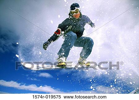 Low angle view of a young man snowboarding View Large Photo Image Stock Photography - Low angle view of a young man snowboarding. Fotosearch