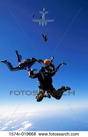 Low angle view of five people skydiving View Large Photo Image Stock Photo - Low angle view of five people skydiving. Fotosearch