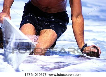 Mid section view of a man with a surfboard View Large Photo Image Stock Image - Mid section view of a man with a surfboard. Fotosearch