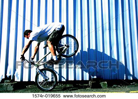 Side profile of a young man performing stunts on a bicycle View Large Photo Image Stock Photography - Side profile of a young man performing stunts on a bicycle. Fotosearch