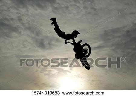 Silhouette of a man performing stunts on a motorcycle View Large Photo Image Stock Image - Silhouette of a man performing stunts on a motorcycle. Fotosearch