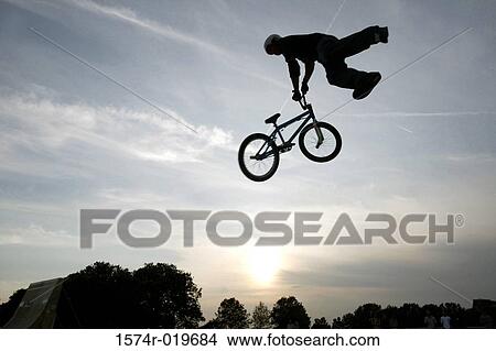 Silhouette of a person performing stunts on a bicycle View Large Photo Image Picture - Silhouette of a person performing stunts on a bicycle. Fotosearch