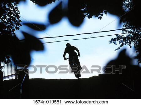 Silhouette of a person riding a bicycle View Large Photo Image Stock Image - Silhouette of a person riding a bicycle. Fotosearch