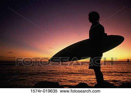 Silhouette of a young man holding a surfboard on the beach View Large Photo Image Stock Photography - Silhouette of a young man holding a surfboard on the beach. Fotosearch