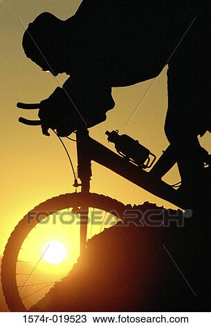 Silhouette of person mountain biking View Large Photo Image Stock Image - Silhouette of person mountain biking. Fotosearch