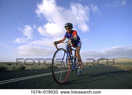 Woman riding bicycle down road View Large Photo Image Stock Image - Woman riding bicycle down road. Fotosearch