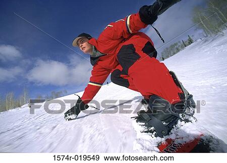 Young adult man snowboarding downhill View Large Photo Image Stock Photo - Young adult man snowboarding downhill. Fotosearch