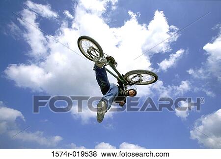 Young man performing stunt on bicycle View Large Photo Image Stock Photo - Young man performing stunt on bicycle. Fotosearch