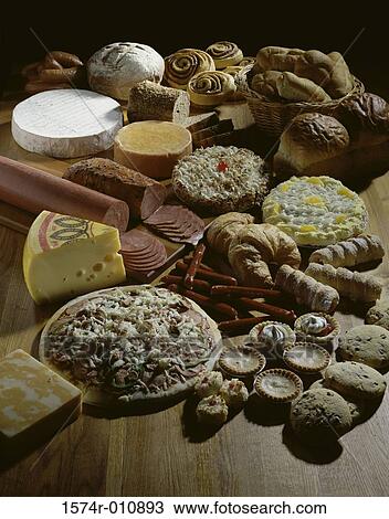 Stock Image - Assorted baked goods laid out with cheeses and meats. Fotosearch