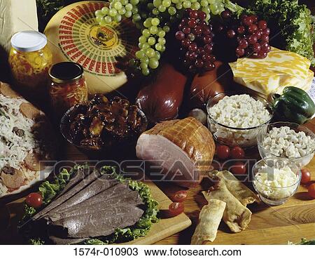 Stock Image - Assorted food preparations served in a buffet with grapes and pickles. Fotosearch