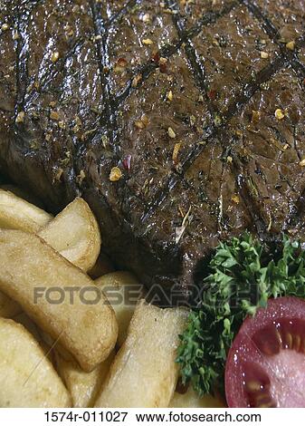 Close-up of grilled meat with French fries View Large Photo Image Stock Photo - Close-up of grilled meat with French fries. Fotosearch
