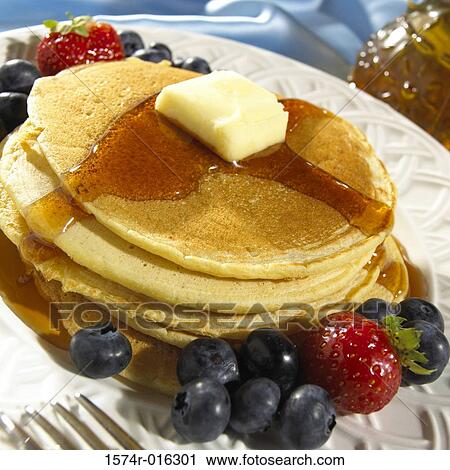 Stock Image - Close-up of pancakes with butter and maple syrup. Fotosearch