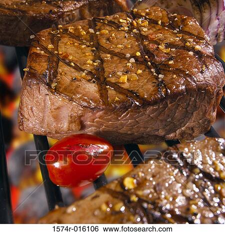 Stock Photograph - Close-up of steaks cooked over a barbecue grill. Fotosearch