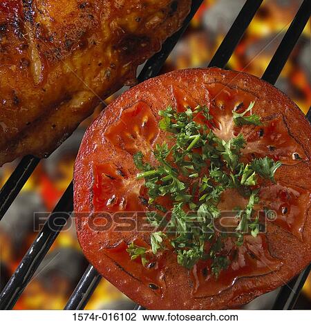 Stock Image - Close-up of tomato cooked over a barbecue grill. Fotosearch