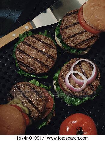 Stock Photo - Hamburgers on a grill with a spatula. Fotosearch